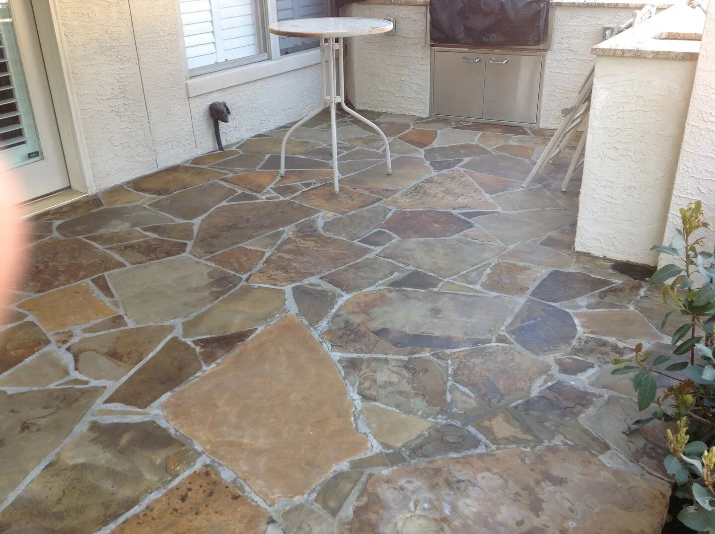 Flagstone patio with a small table beside an outdoor kitchen